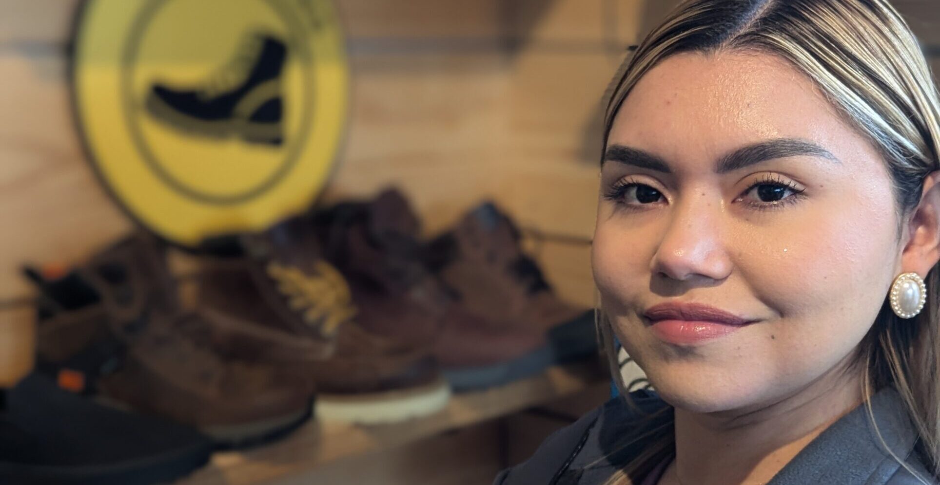 Erica standing beside a display of work boots at the Work Hard Dress Right store in Newark.