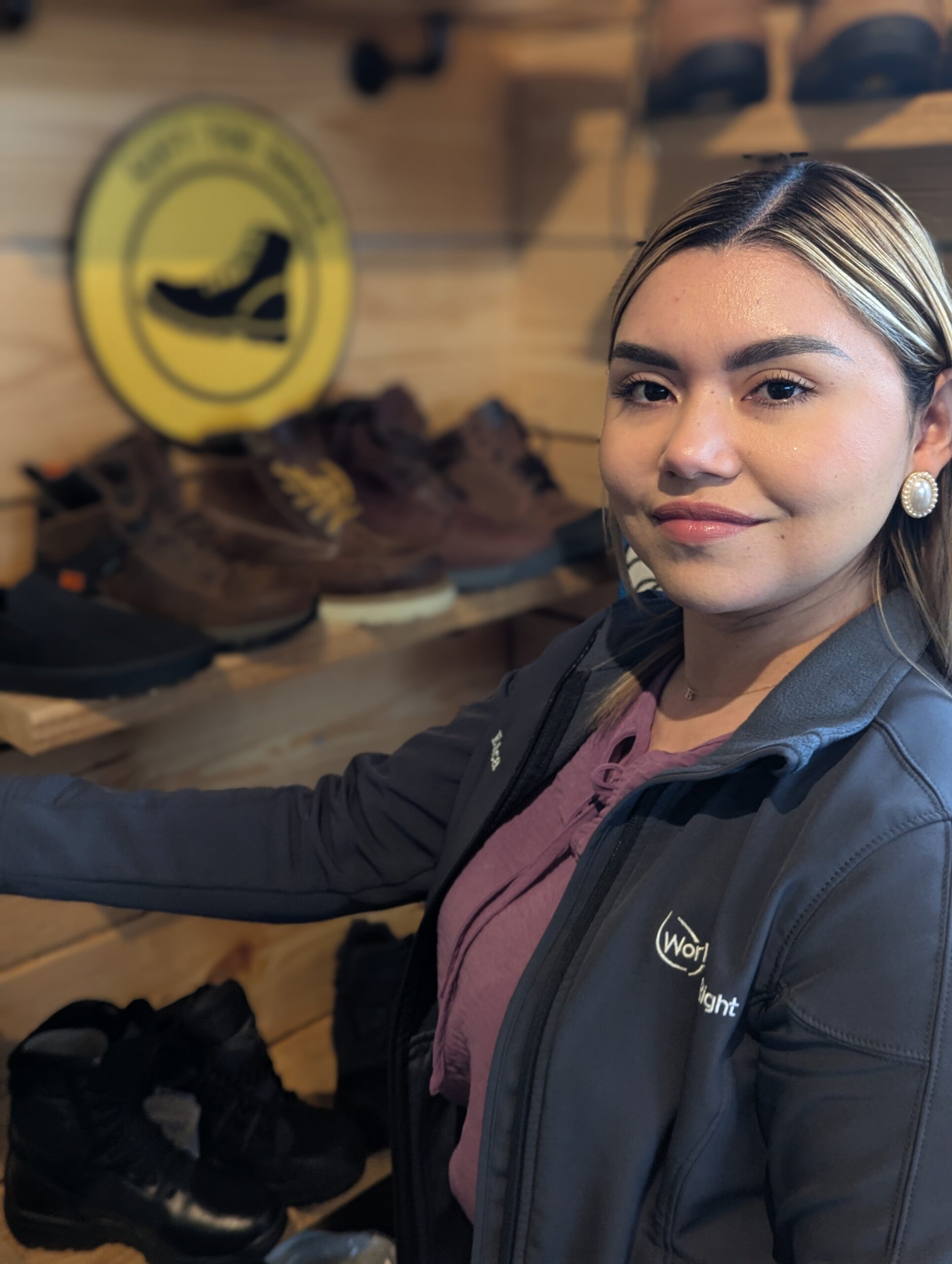 Erica standing beside a display of work boots at the Work Hard Dress Right store in Newark.