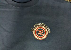 Company logo applied to branded apparel using heat transfer decoration showing color and texture differences