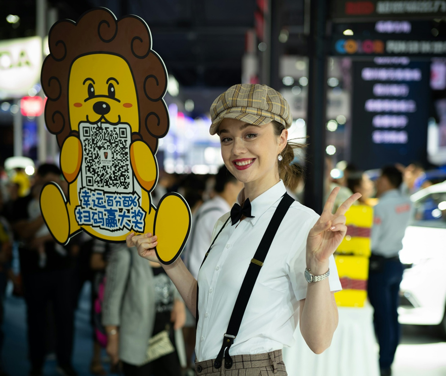 Trade show attendee holding QR code sign encouraging visitors to scan for information and follow up