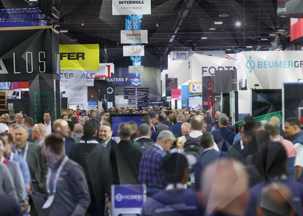 Crowded trade show floor with attendees walking past booths, illustrating how booth design can limit engagement and interaction