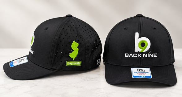 Custom embroidered Back Nine Golf caps featured in the October 2026 SOLUTIONS newsletter